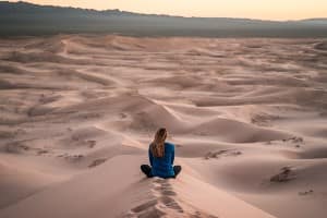 woman contemplating on a sand dune