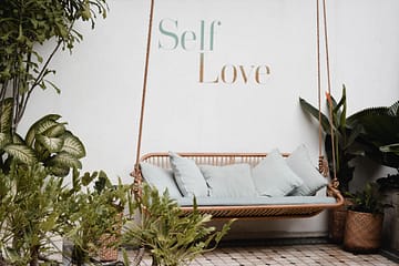 outdoor swing with sign that says Self Love